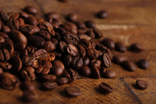 Kaffeebohnen auf rustikalem Holzgrund — Stockfoto