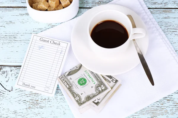 Cheque, dinero y taza de café en primer plano de la mesa —  Fotos de Stock