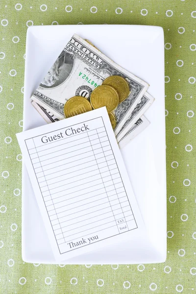 Scheck und Geld auf Tablett auf Tisch in Großaufnahme — Stockfoto