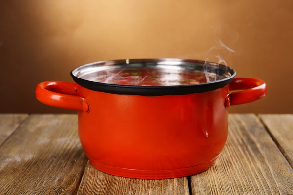 蒸煮锅与蒸汽上棕色背景表格 — 图库照片