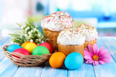 Sweet Easter cakes with colorful eggs on table in room clipart