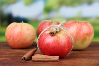 Olgun elma ile parlak zemin üzerine ahşap masa üzerine tarçın ile