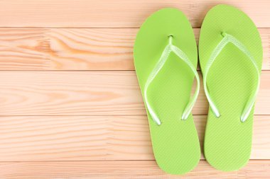 ahşap zemin üzerinde parlak parmak arası terlik