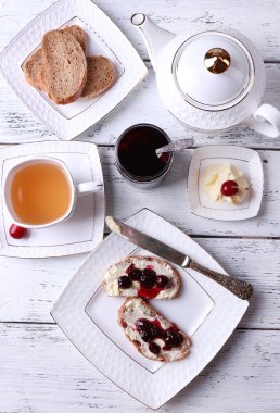 kiraz reçeli ve ahşap zemin üzerinde plaka üzerinde ev yapımı tereyağı ile taze ekmek