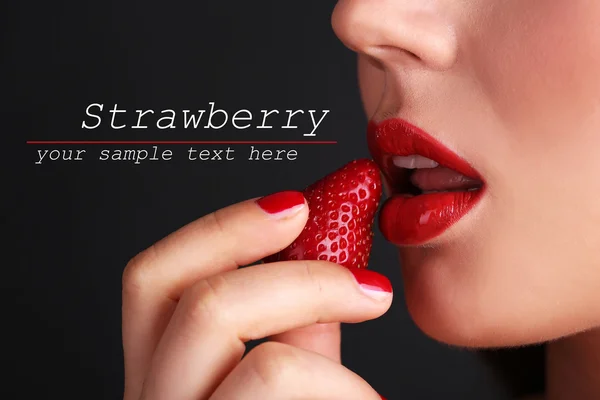 Flicka med röda läppar, naglar och jordgubbar på mörk bakgrund — Stockfoto