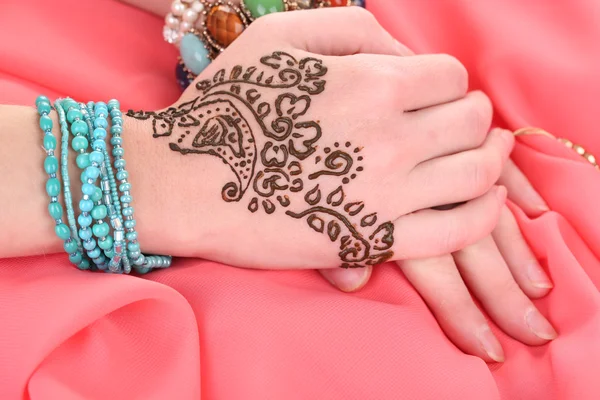 Hands painted with henna on color cloth background — Stock Photo, Image