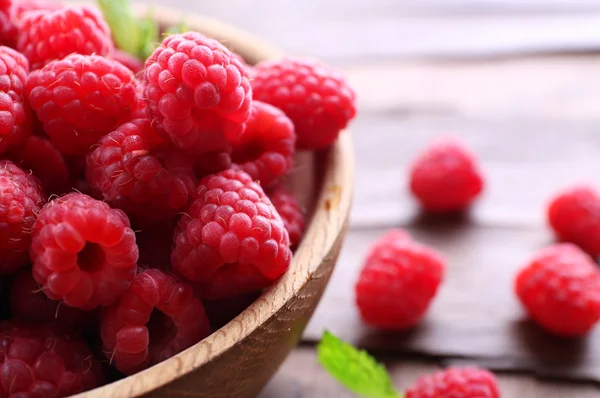 Ripe sweet raspberries in bowl on table close-up — Stock Photo, Image