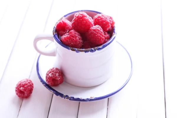 Rijpe zoete frambozen in cup op tabel close-up — Stockfoto