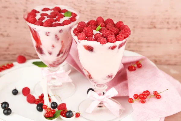 Sabroso postre de frambuesa con bayas sobre fondo de madera rosa — Foto de Stock