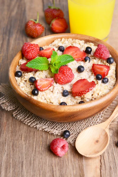 Tasty oatmeal with berries on table close-up — Stock Photo, Image