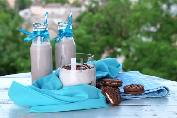 Süt kokteyl gözlük ve tablo doğal zemin üzerine çikolatalı kurabiye — Stok fotoğraf