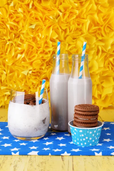 Mléčné koktejly v brýle a čokoládové cookies na žlutém podkladu — Stock fotografie