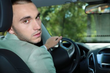 Arabada oturan adam.