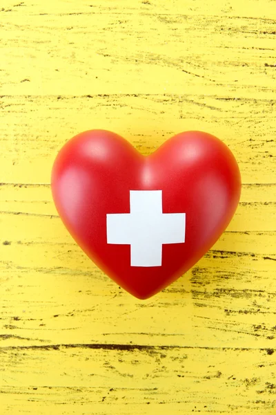 Красное сердце с крестиком — стоковое фото