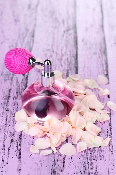 Perfume bottle with petals — Stock Photo, Image