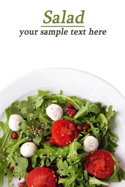 Green salad made with  arugula, tomatoes, cheese mozzarella balls and sesame  on plate, isolated on white — Stock Photo, Image