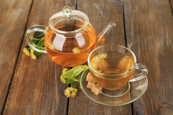 Chutný bylinkový čaj s lipové květy na dřevěný stůl — Stock fotografie