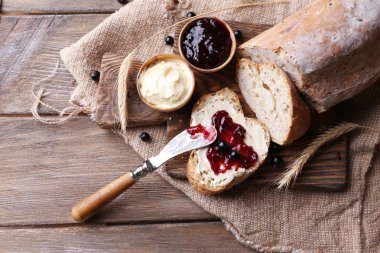 taze ekmek ile ev yapımı tereyağı ve blackcurrant jam ahşap arka plan üzerinde