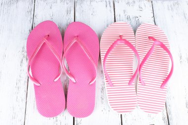 ahşap arka plan üzerinde renkli parmak arası terlik