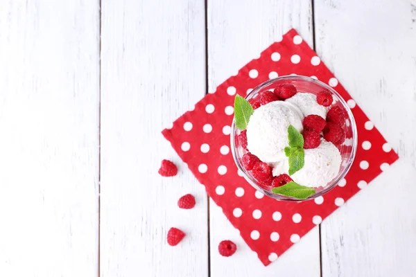 Creamy ice cream with raspberries on plate in glass bowl, on color wooden background — Stock Photo, Image