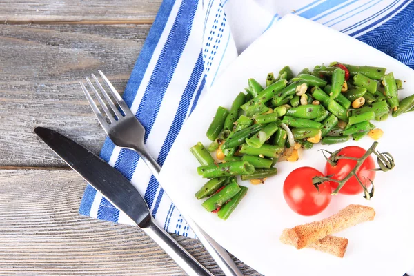 Salad with green beans, ham and  corn on plate, on color wooden background — Stock Photo, Image