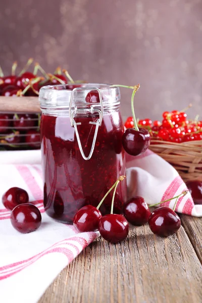 Jam in glazen pot op tafel, bessen close-up — Stockfoto