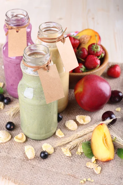 Bottles of delicious smoothie on table, close-up — Stock Photo, Image
