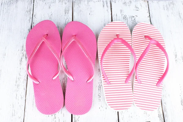 Flip-flops berwarna-warni pada latar belakang kayu — Stok Foto