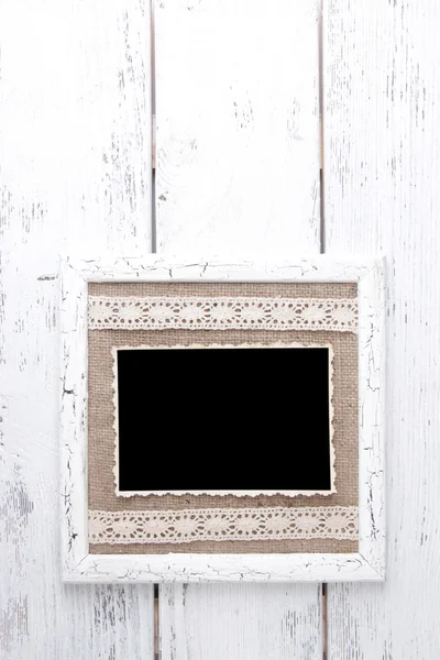 Wooden frame with blank old photo on wooden background — Stock Photo, Image