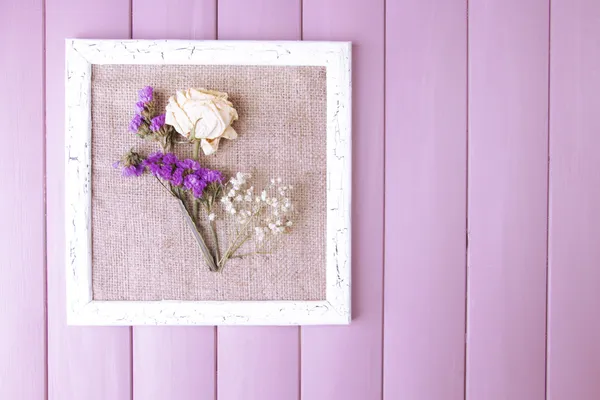 Houten frame met gedroogde bloemen op houten achtergrond — Stockfoto