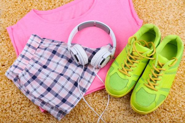 Ropa deportiva, zapatos y auriculares sobre fondo de alfombra de color . —  Fotos de Stock