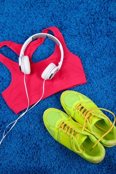 Ropa deportiva, zapatos y auriculares sobre fondo de alfombra de color . —  Fotos de Stock