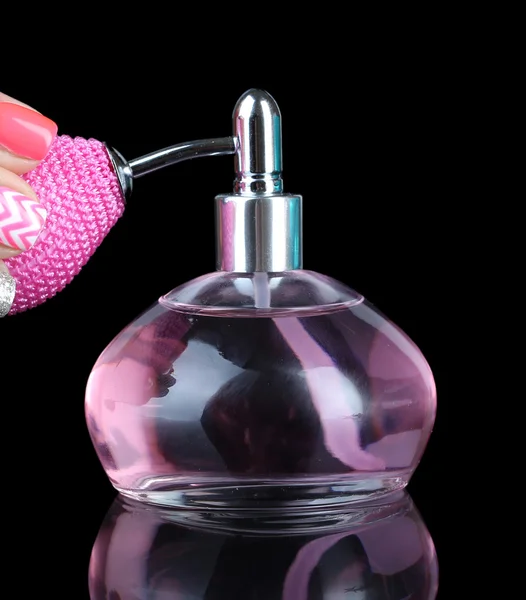 Perfume bottle with hand isolated on black — Stock Photo, Image