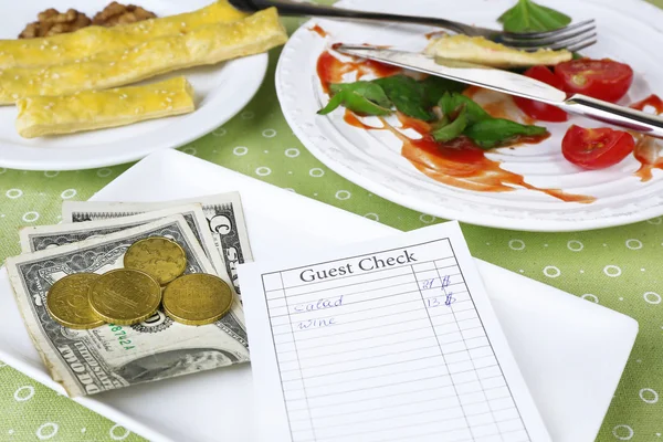 Comprobar y restos de comida en la mesa en el restaurante — Foto de Stock