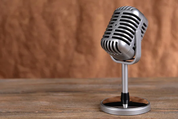 stock image Vintage microphone on table on brown background