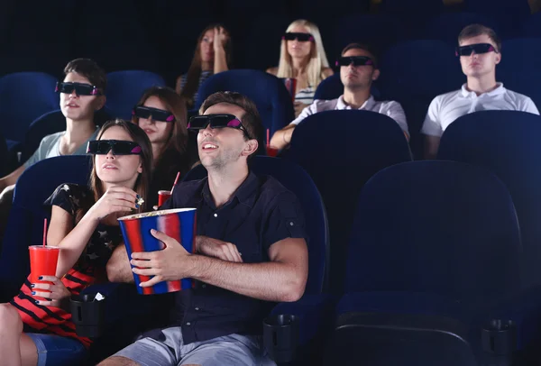 Mladí lidé sledující film v kině Stock Obrázky