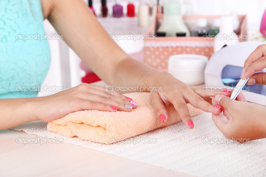 Young woman is getting manicure
