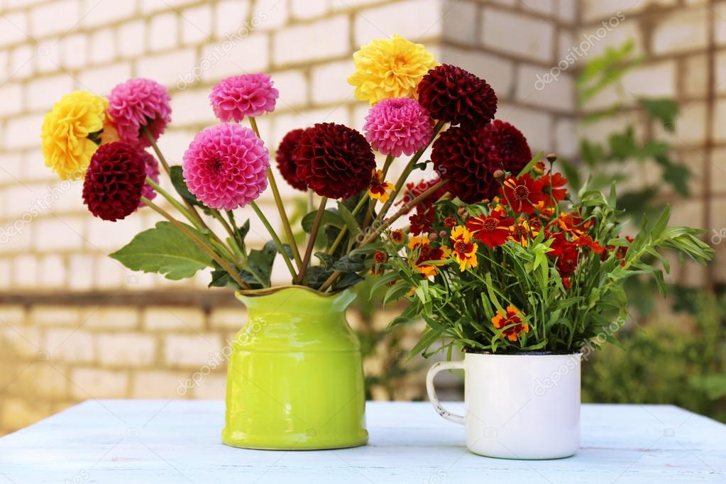 Dahlia flowers in vase on table, outdoors