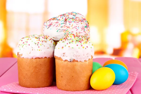 Gâteaux de Pâques sucrés avec des œufs colorés sur la table dans la chambre — Photo