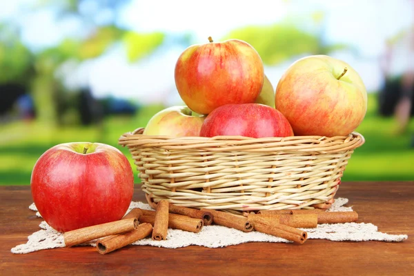 Érett alma, fahéj rúd a fából készült asztal, a világos háttér — Stock Fotó