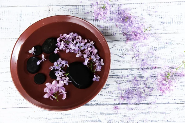 Cuenco con ingredientes naturales del spa y agua perfumada sobre fondo de madera —  Fotos de Stock