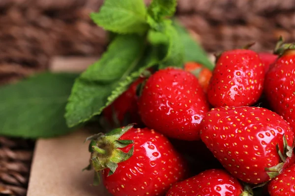 Reife süße Erdbeeren auf Papierserviette auf Weidenmatte Hintergrund — Stockfoto