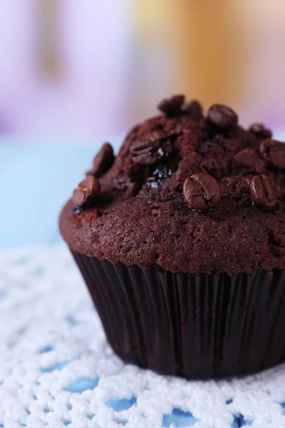 Schokoladenmuffin auf Holztisch, auf hellem Hintergrund — Stockfoto