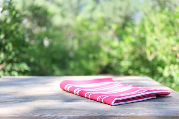 Wooden table with tablecloth, outdoors — Stock Photo, Image