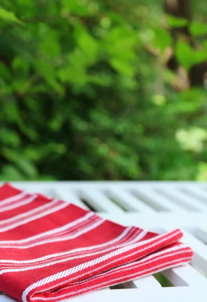 Wooden table with tablecloth, outdoors — Stock Photo, Image