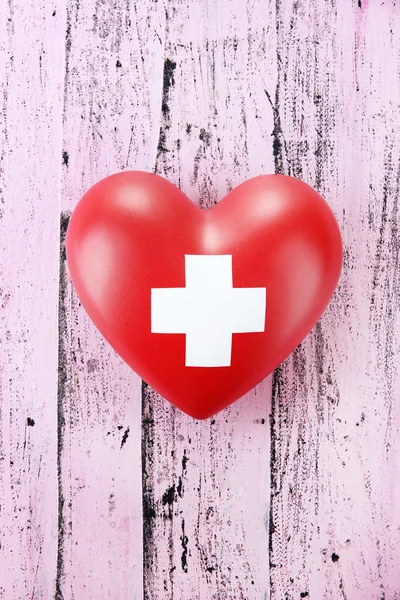 Красное сердце с крестиком — стоковое фото