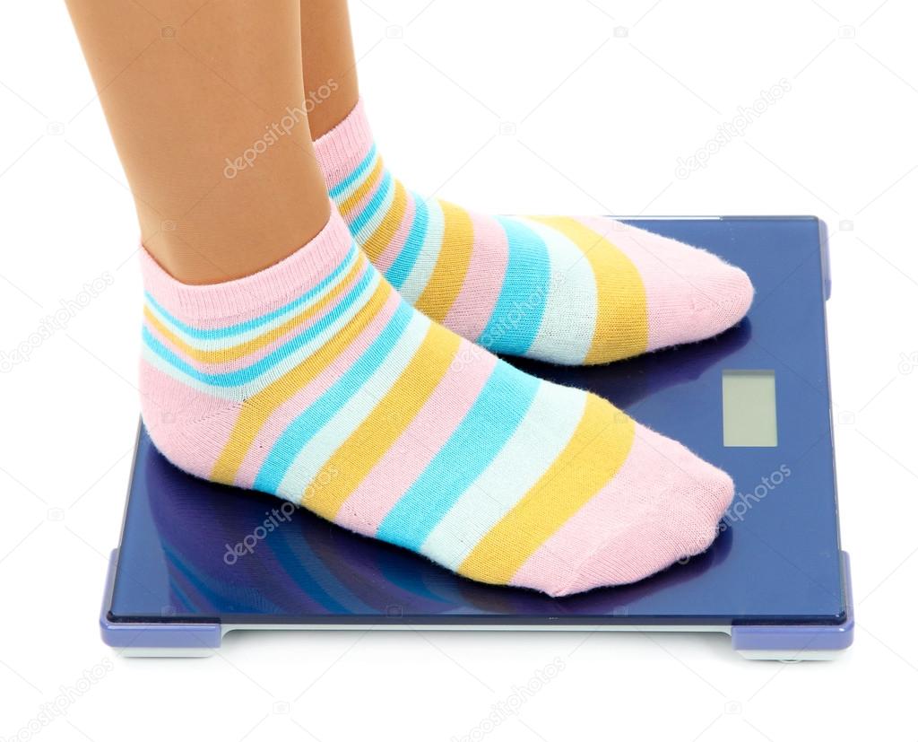 Feet on scales isolated on white