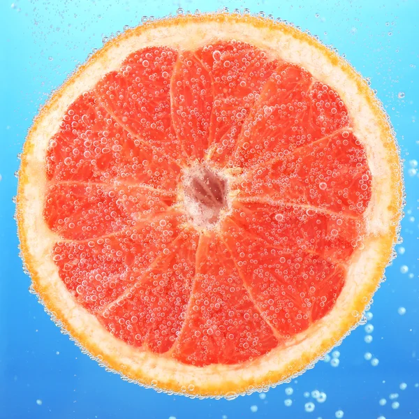 Fresh grapefruit in water — Stock Photo, Image