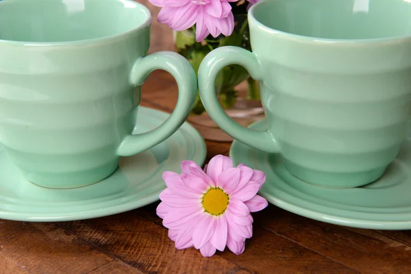 Cups and saucers with flowers — Stock Photo, Image
