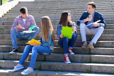 merdiven parkta oturan mutlu öğrenciler